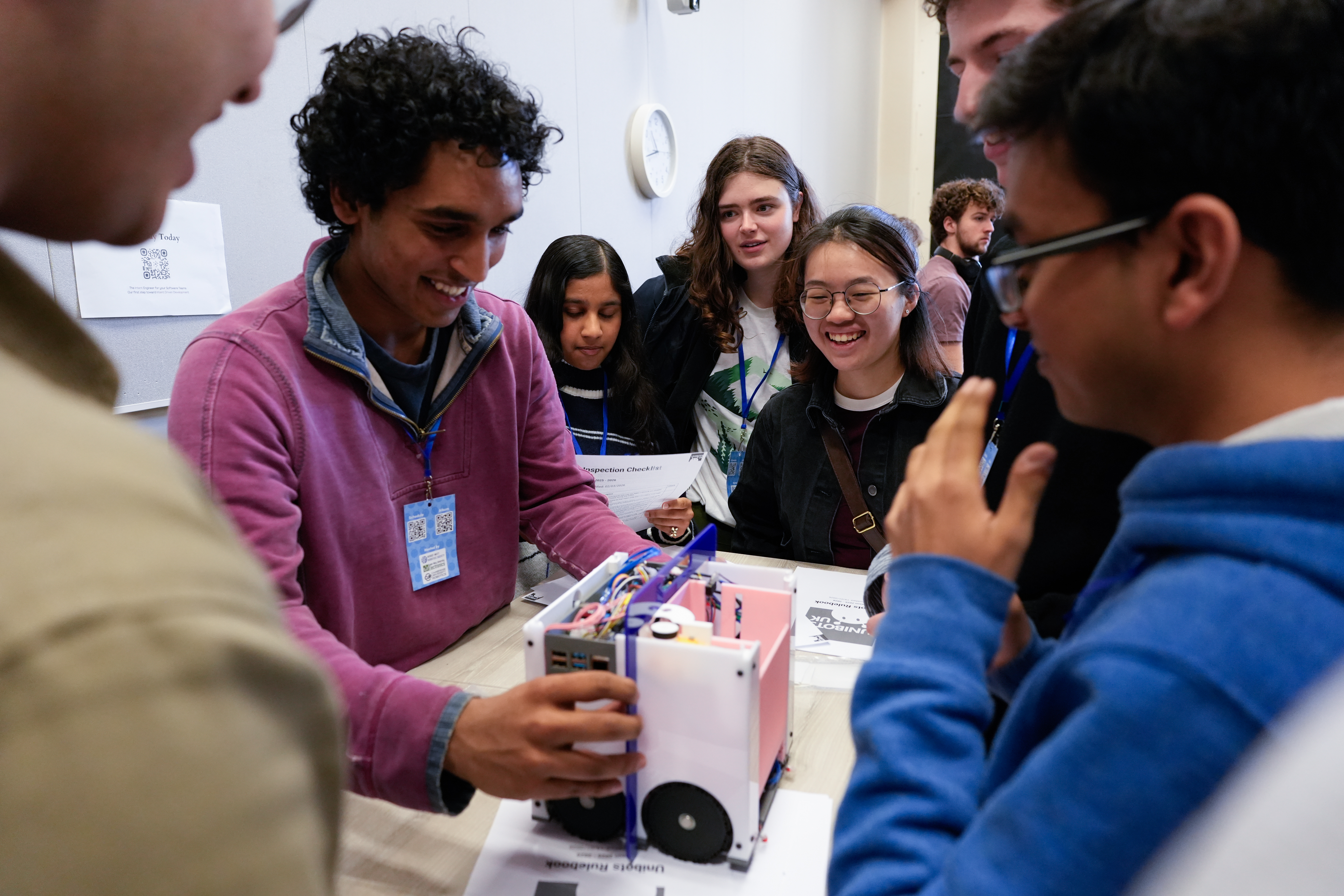 Students cheering around a robot at a Unibots event