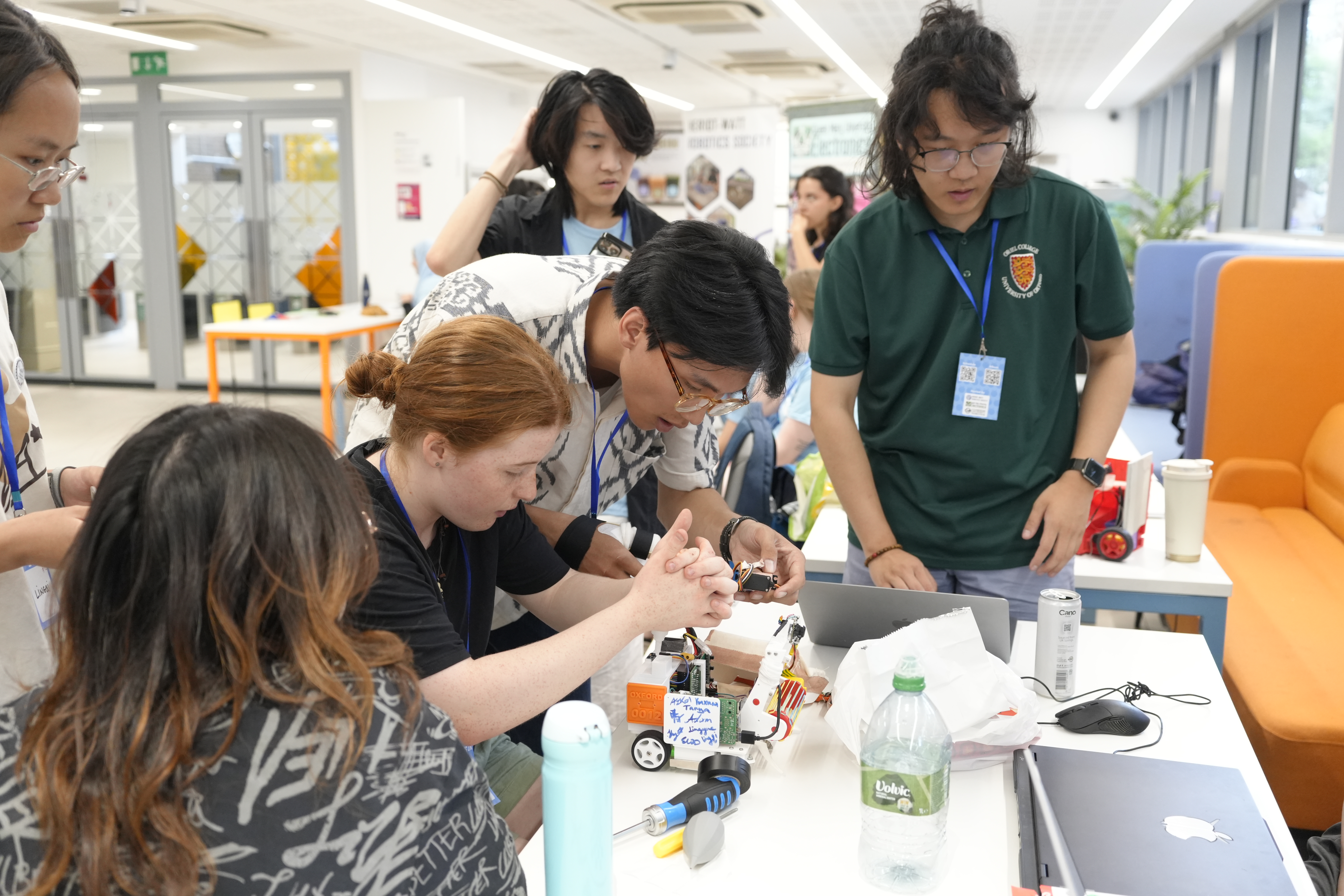 Students working together to repair a robot beside the competition arena