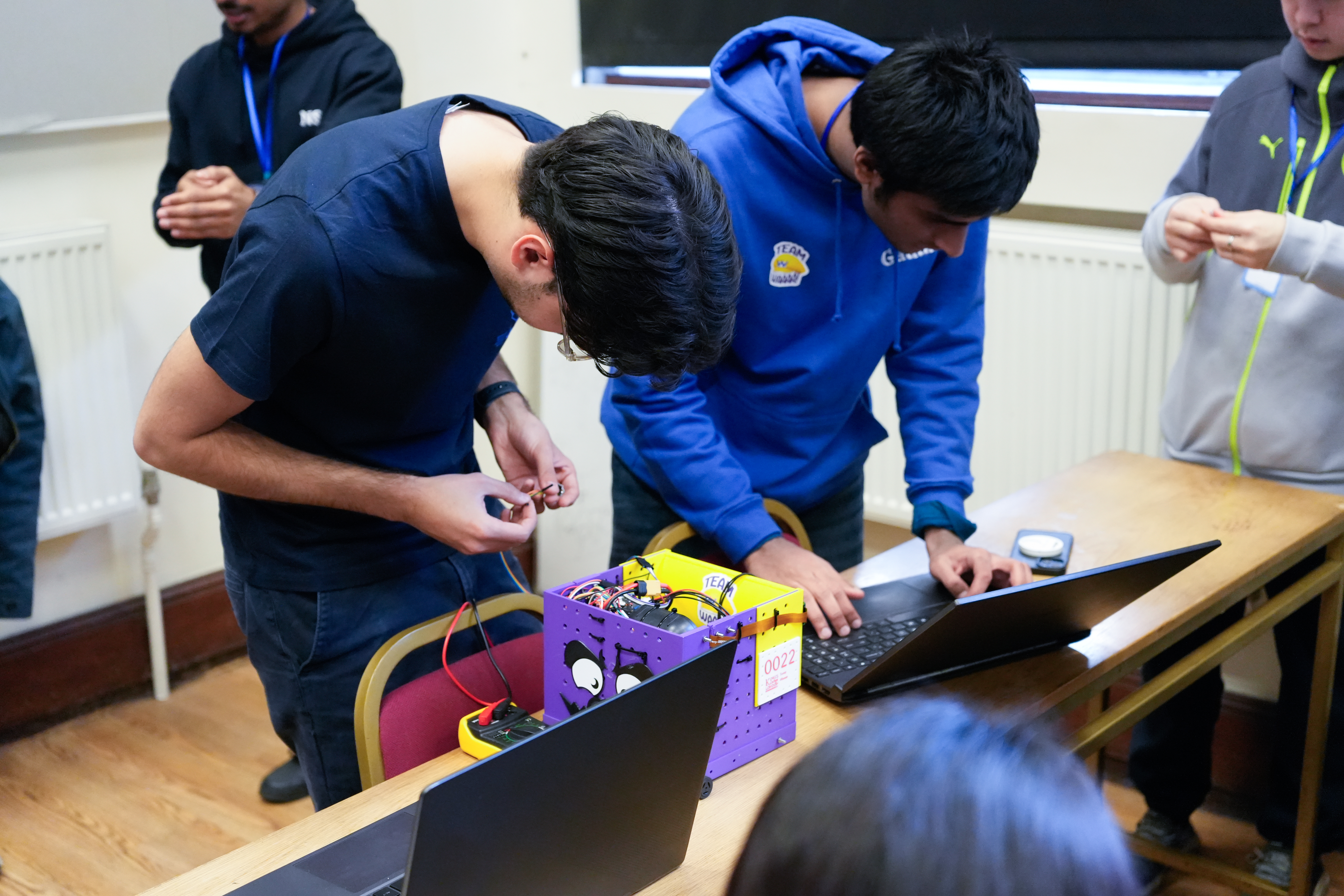 Students fixing a robot during a Unibots event